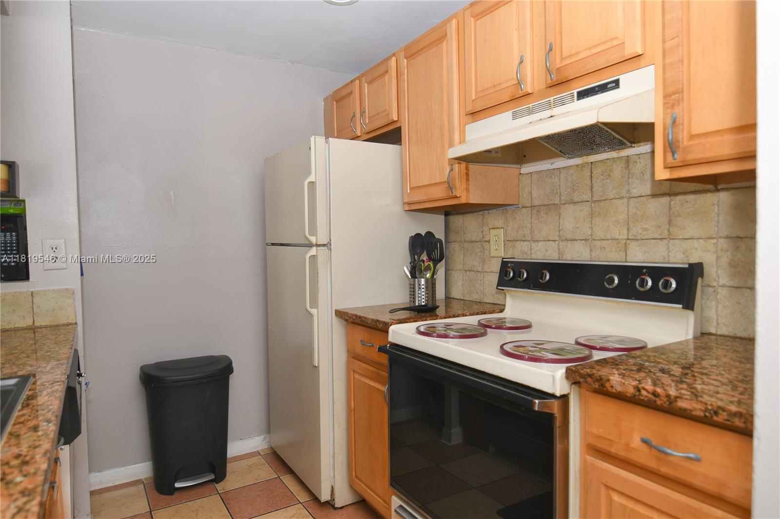 7125 Northwest 186th Street, Unit B311 Hialeah, FL 33015 - Photo 12 of 31 a kitchen with stainless steel appliances granite countertop a stove a refrigerator and a microwave