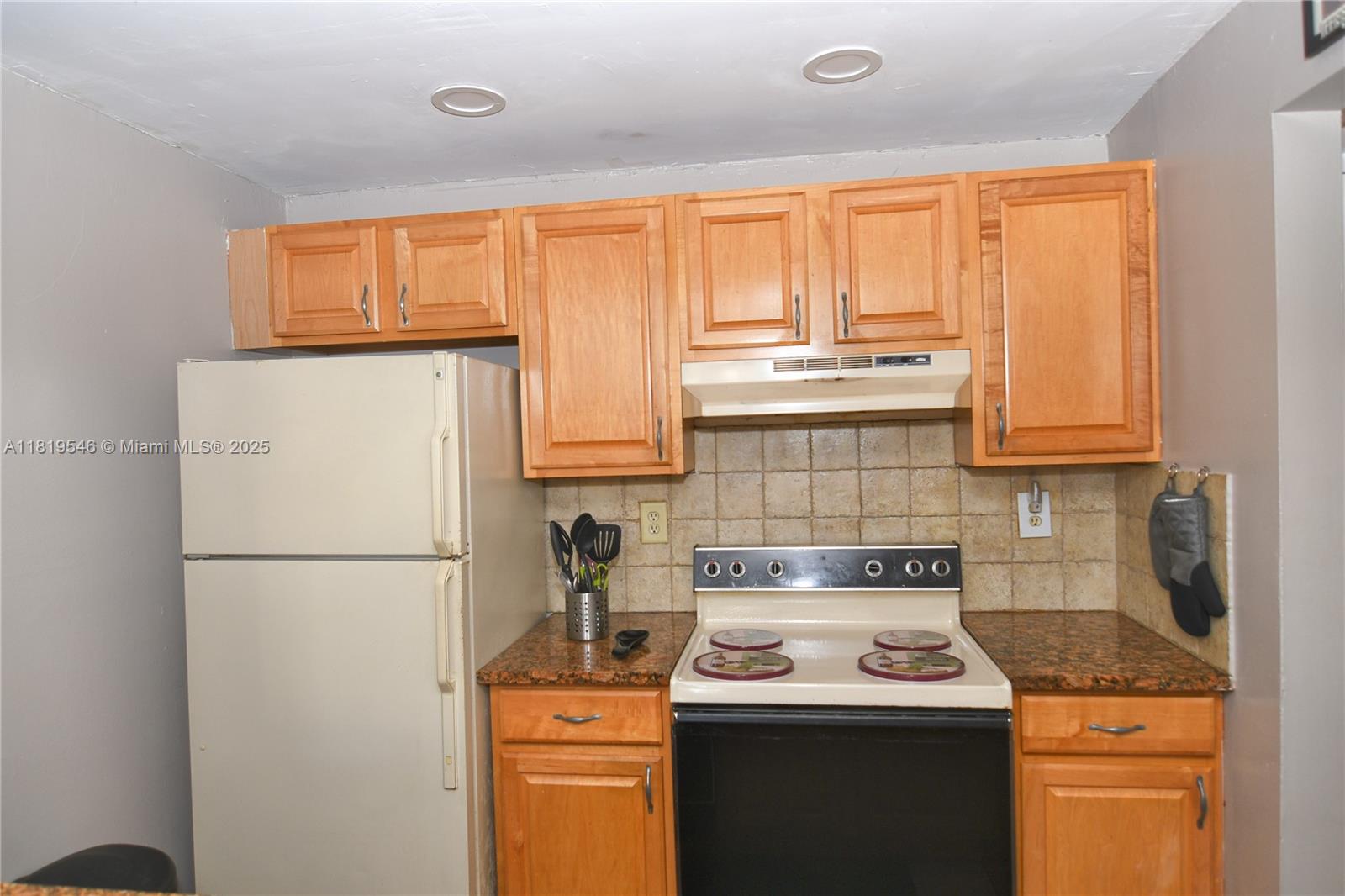 7125 Northwest 186th Street, Unit B311 Hialeah, FL 33015 - Photo 14 of 31 a kitchen with stainless steel appliances granite countertop a refrigerator sink stove and cabinets