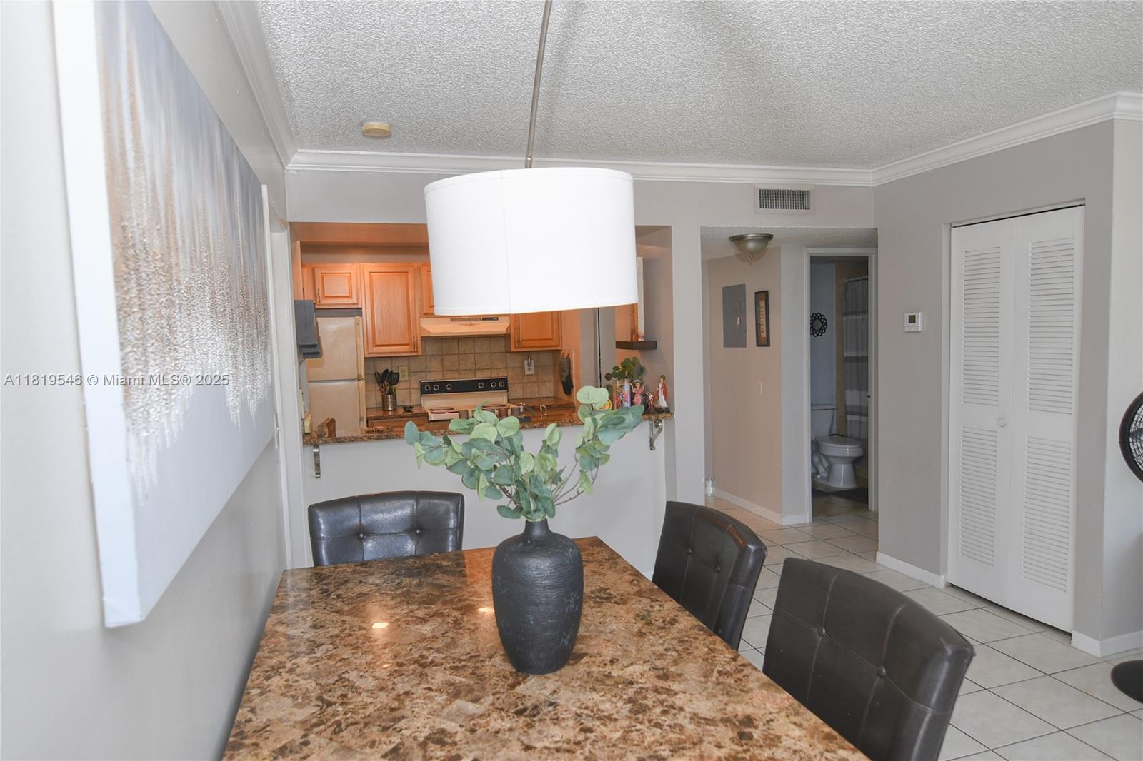 7125 Northwest 186th Street, Unit B311 Hialeah, FL 33015 - Photo 16 of 31 a dining room with furniture and a potted plant