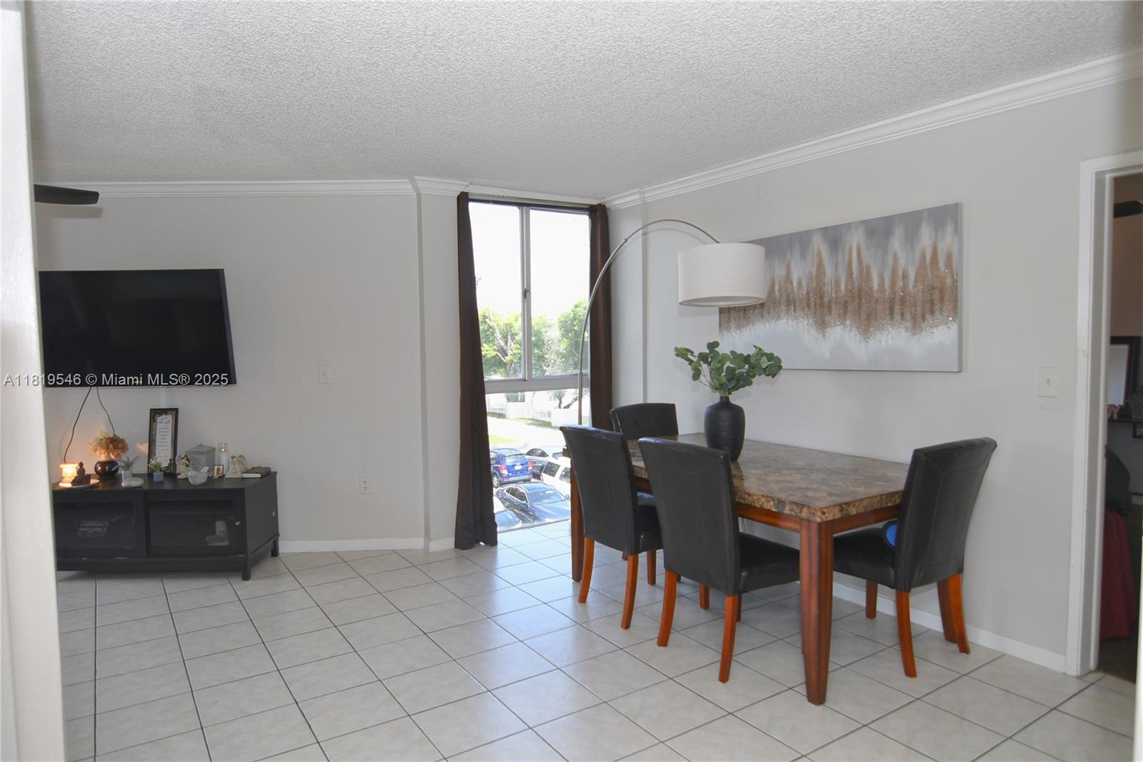 7125 Northwest 186th Street, Unit B311 Hialeah, FL 33015 - Photo 17 of 31 a view of a livingroom with furniture and a flat screen tv