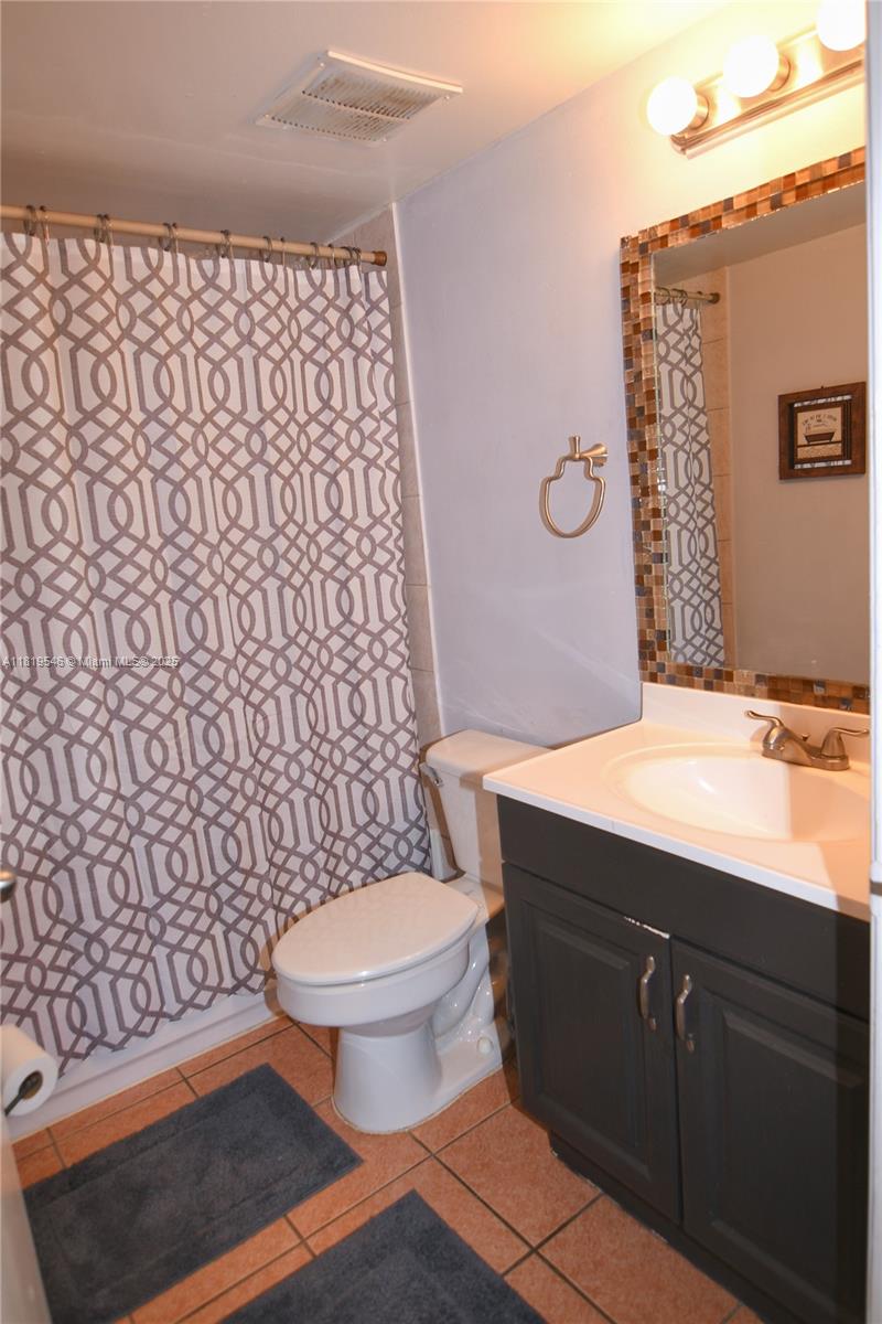 7125 Northwest 186th Street, Unit B311 Hialeah, FL 33015 - Photo 20 of 31 a bathroom with a granite countertop toilet sink and mirror