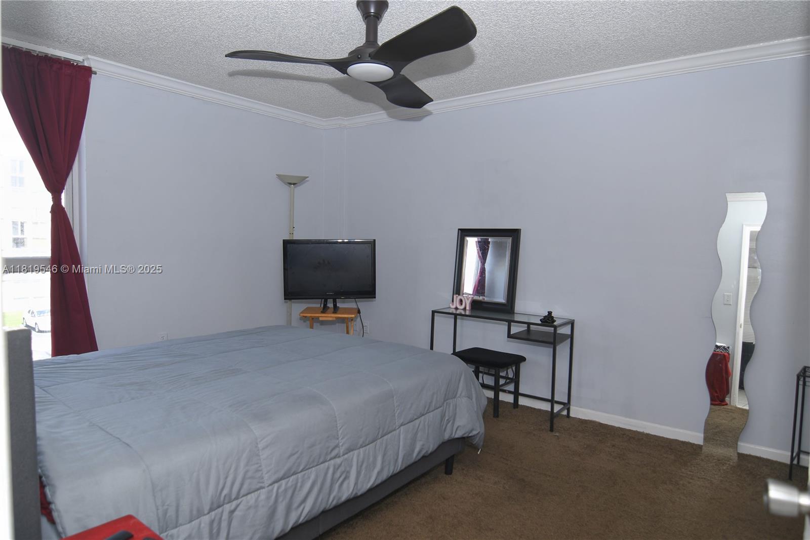 7125 Northwest 186th Street, Unit B311 Hialeah, FL 33015 - Photo 24 of 31 a bedroom with a bed a desk and chair