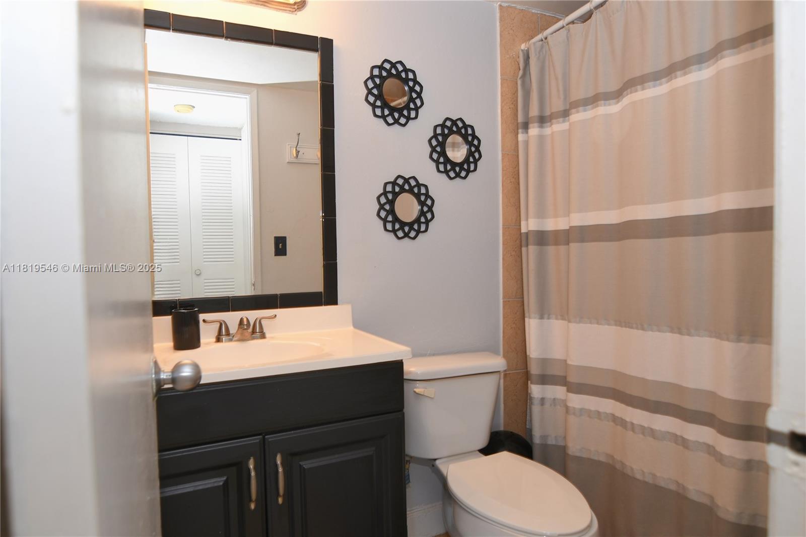 7125 Northwest 186th Street, Unit B311 Hialeah, FL 33015 - Photo 8 of 31 a bathroom with a toilet sink vanity and mirror