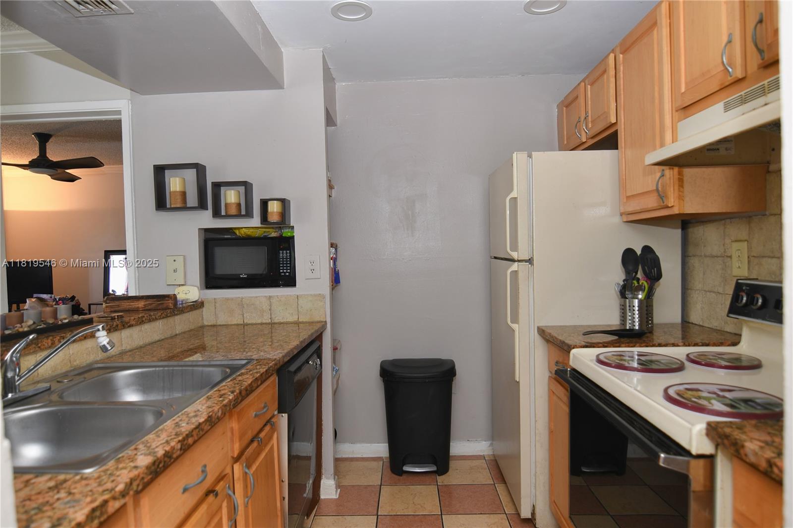 7125 Northwest 186th Street, Unit B311 Hialeah, FL 33015 - Photo 10 of 31 a kitchen with stainless steel appliances granite countertop a sink stove and refrigerator