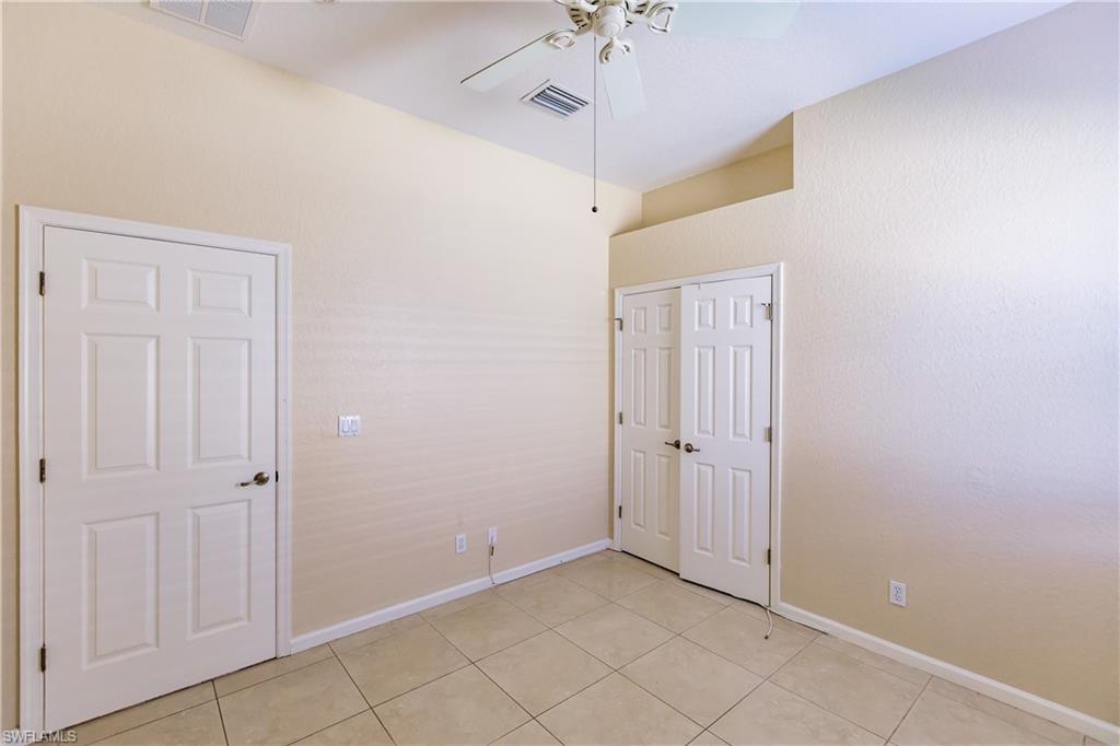 7868 Founders Circle Naples, FL 34104 - Photo 12 of 28 an empty room with windows and ceiling fan