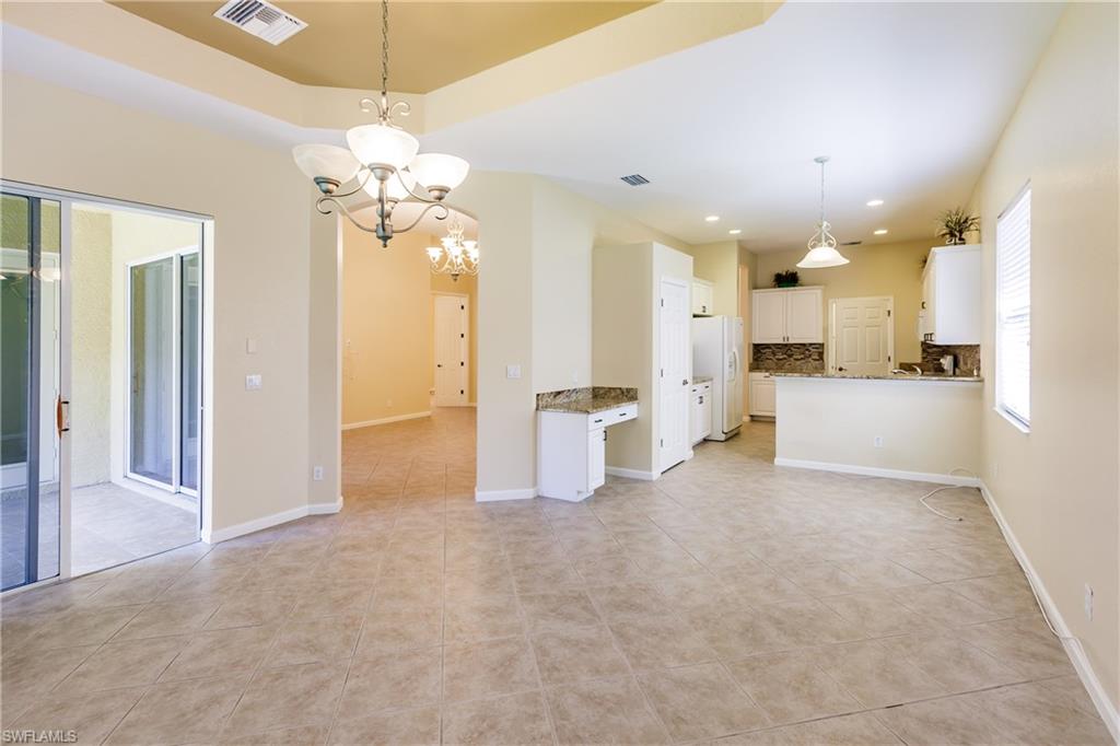 7868 Founders Circle Naples, FL 34104 - Photo 23 of 28 a view of a kitchen with a refrigerator windows and a chandelier