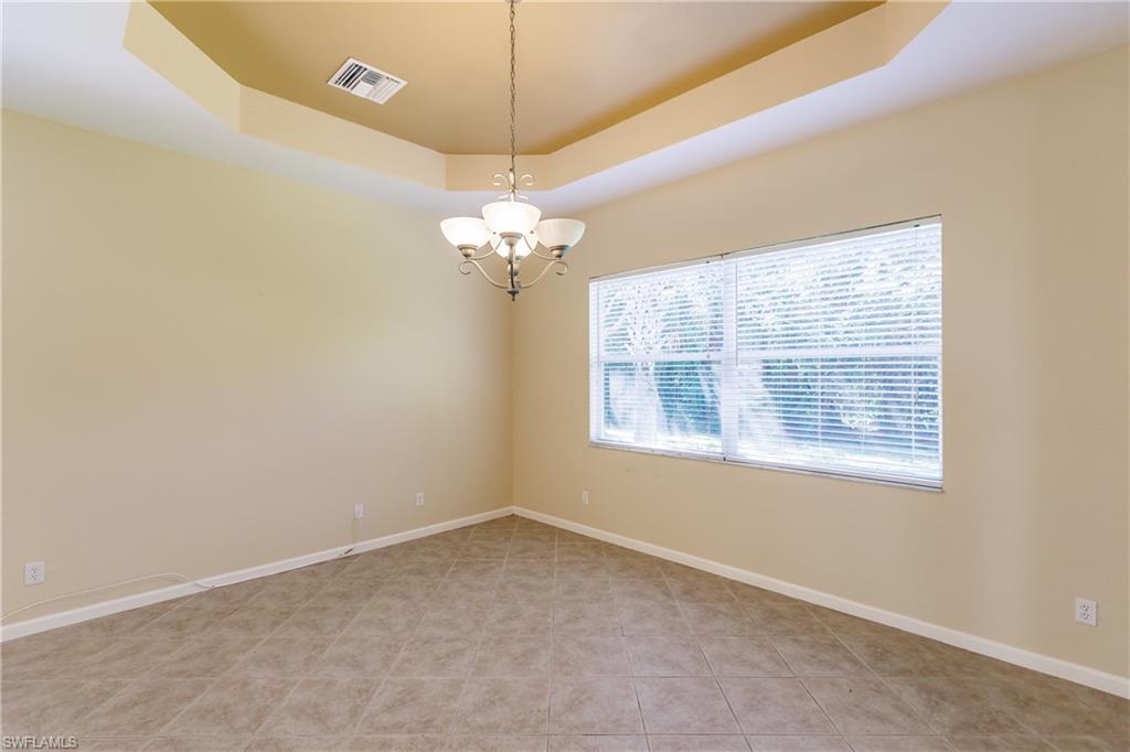 7868 Founders Circle Naples, FL 34104 - Photo 25 of 28 en empty room with windows and chandelier