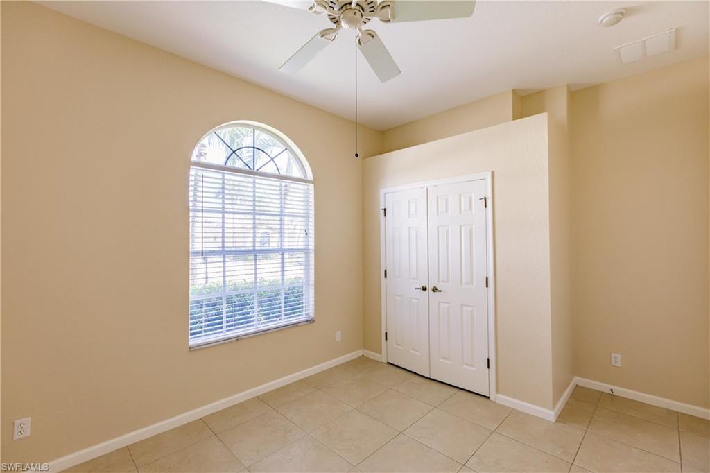7868 Founders Circle Naples, FL 34104 - Photo 8 of 28 an empty room with fan and windows
