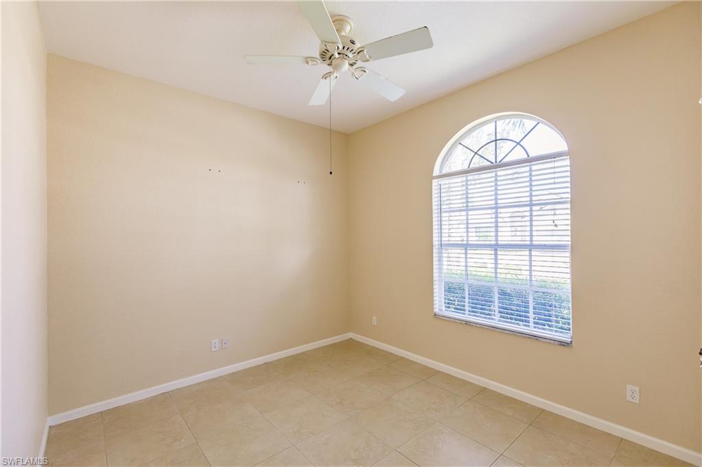 7868 Founders Circle Naples, FL 34104 - Photo 10 of 28 an empty room with windows and ceiling fan
