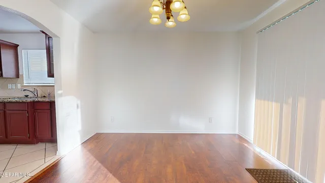 a view of hallway with wooden floor and cabinet