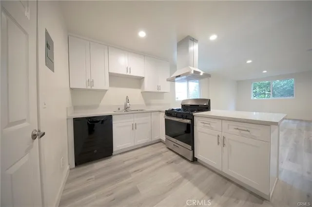 a kitchen with granite countertop a sink stainless steel appliances and cabinets