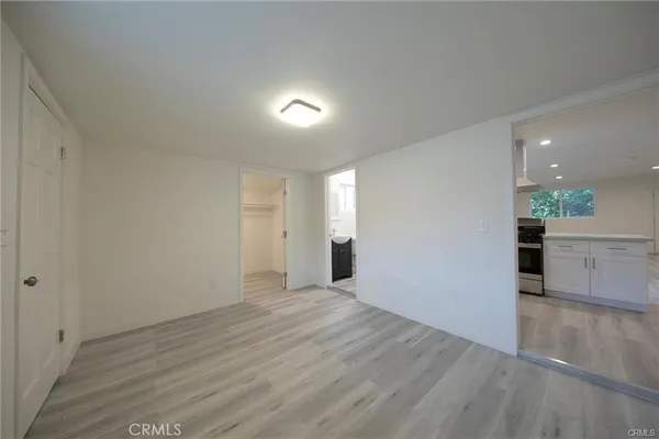a view of a big room with wooden floor and windows