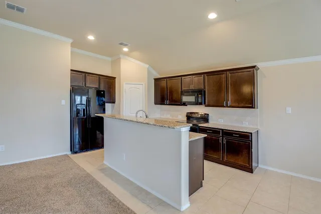 a kitchen with stainless steel appliances granite countertop a sink refrigerator and cabinets