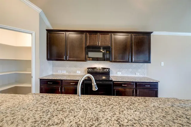 a kitchen with granite countertop a sink and a stove