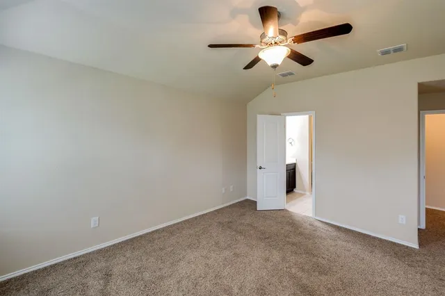 an empty room with a ceiling fan and a fan
