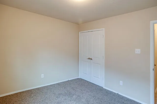 an empty room with a window and wooden floor