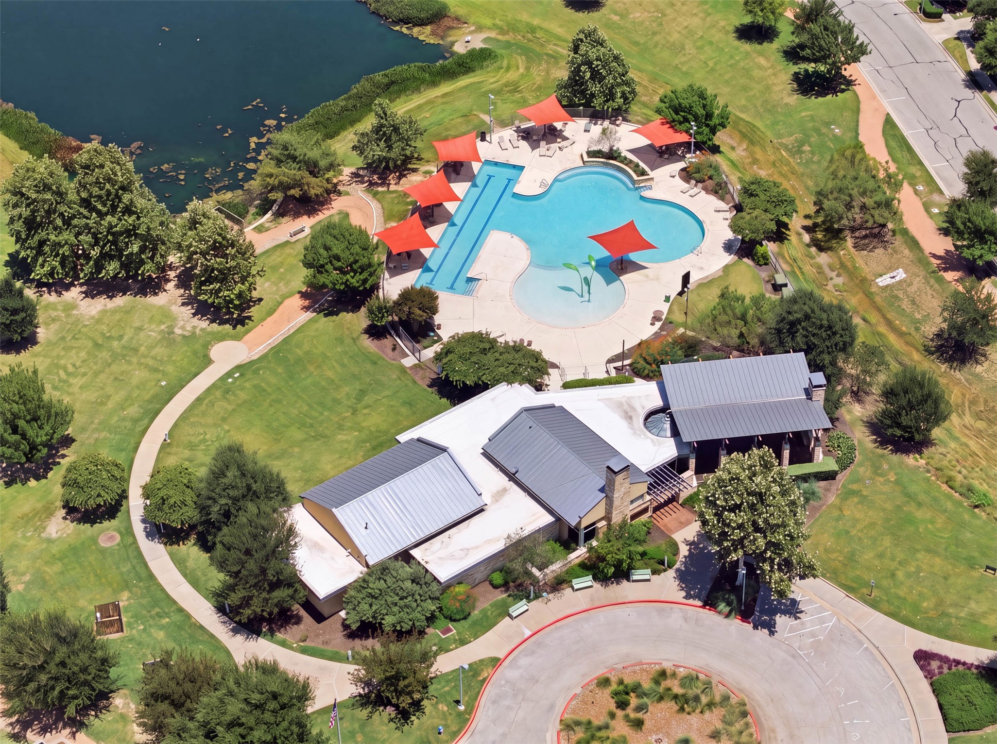 3101 Rabbit Creek Drive Georgetown, TX 78626 - Photo 35 of 38 An aerial perspective reveals a vibrant community pool area nestled beside a serene lake.