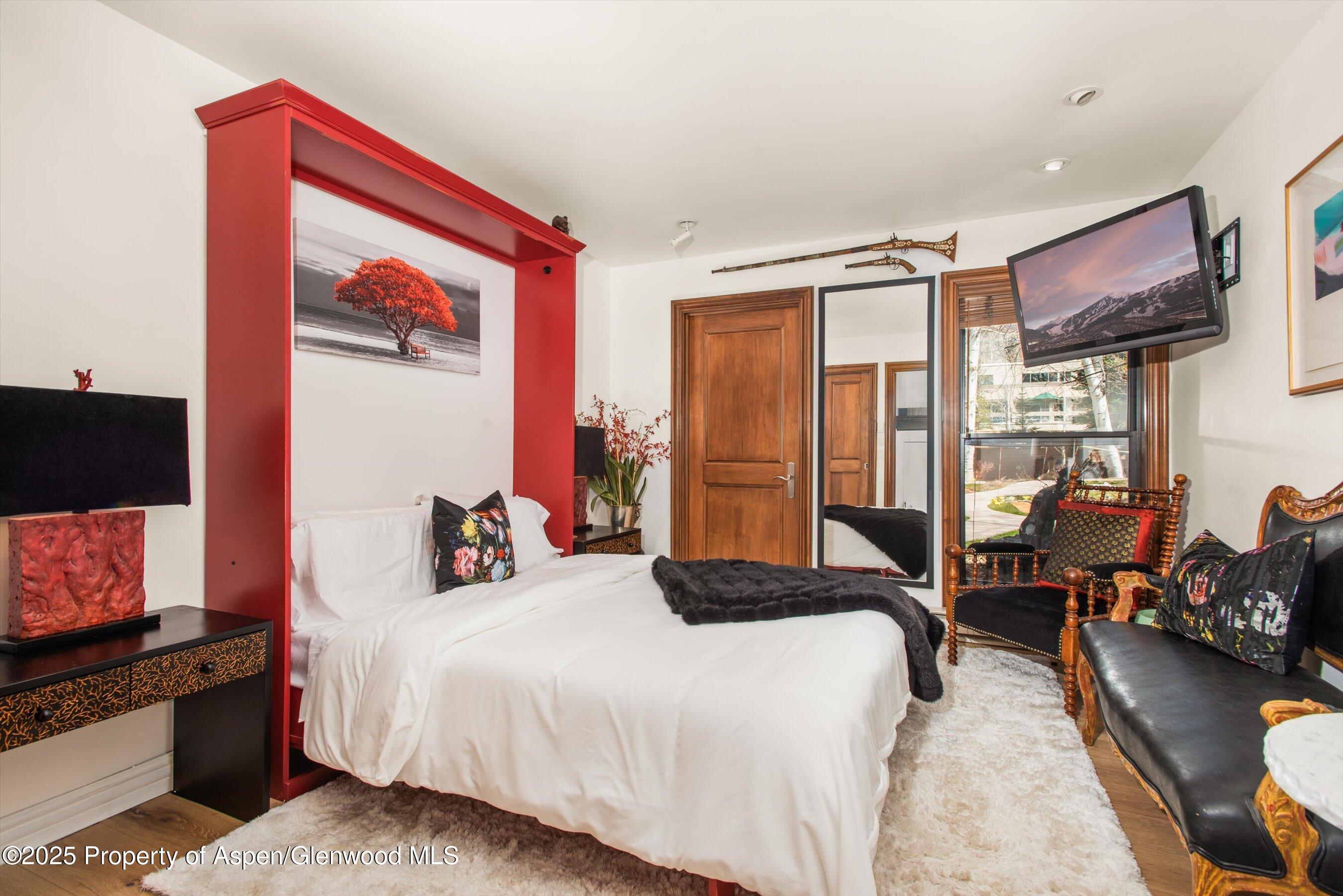 155 Lone Pine Road, Unit 9 Aspen, CO 81611 - Photo 18 of 27 a bedroom with a bed and wooden floor