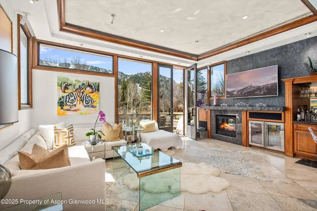 a living room with furniture a floor to ceiling window and a flat screen tv