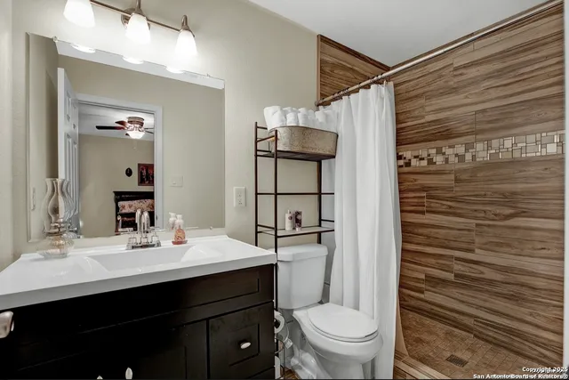 a bathroom with a sink toilet vanity and shower