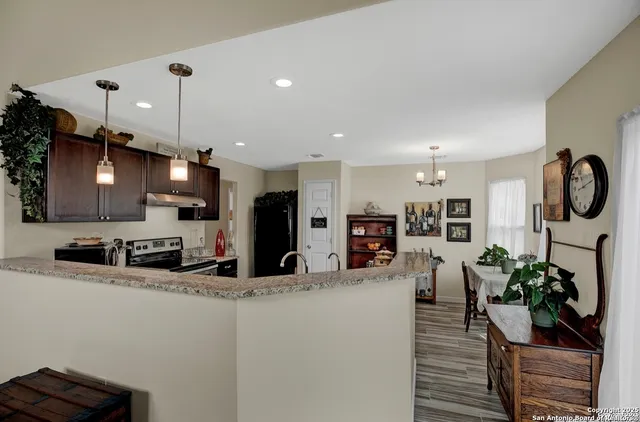 a kitchen with stainless steel appliances kitchen island granite countertop a sink a stove and cabinets