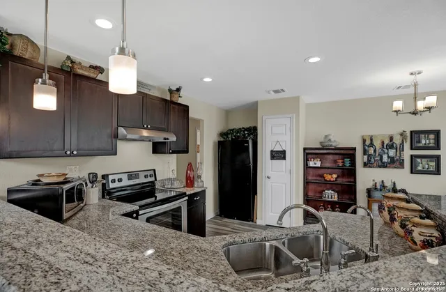 a kitchen with stainless steel appliances granite countertop a sink refrigerator and stove