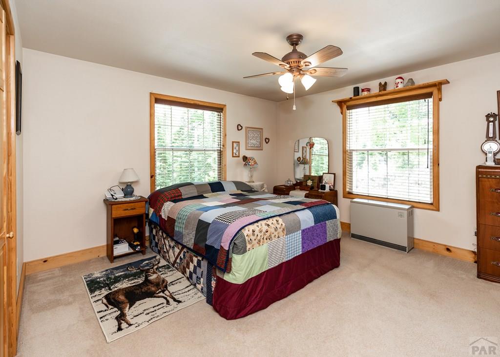 331 Westcliffe Drive Rye, CO 81069 - Photo 35 of 48 a bedroom with a bed and a chandelier