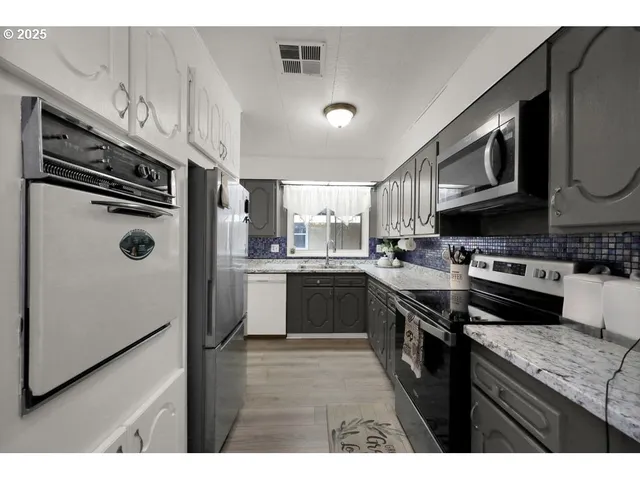 a kitchen with stainless steel appliances granite countertop a stove sink and cabinets