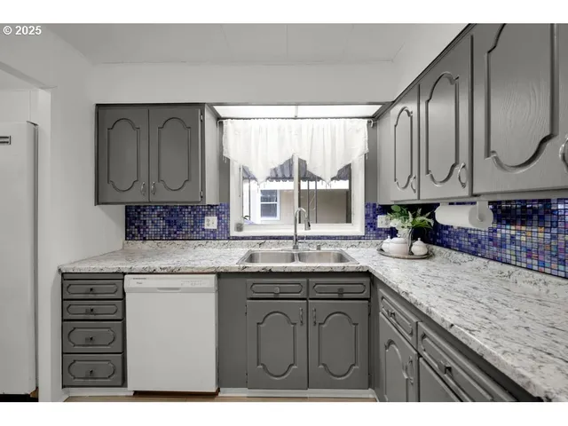 a kitchen with granite countertop a sink stainless steel appliances and cabinets