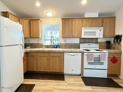 a kitchen with kitchen island granite countertop a sink stainless steel appliances and cabinets