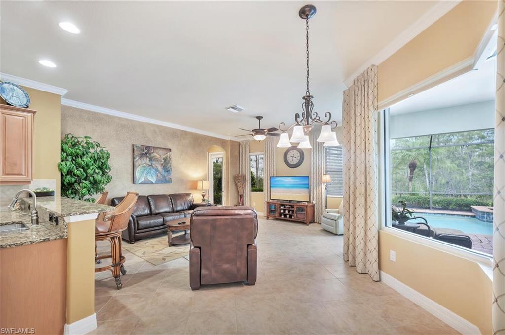 21093 Torre Del Lago Street Estero, FL 33928 - Photo 11 of 37 a view of a dining room and a livingroom with furniture wooden floor a chandelier