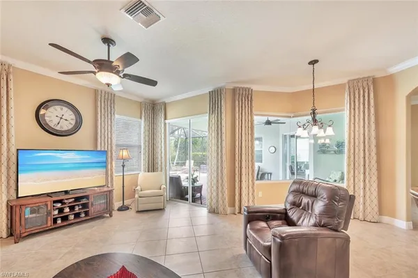 a living room with furniture a flat screen tv and a window