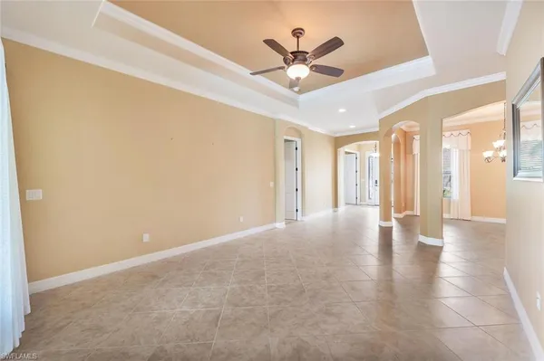 a view of an empty room with a chandelier fan