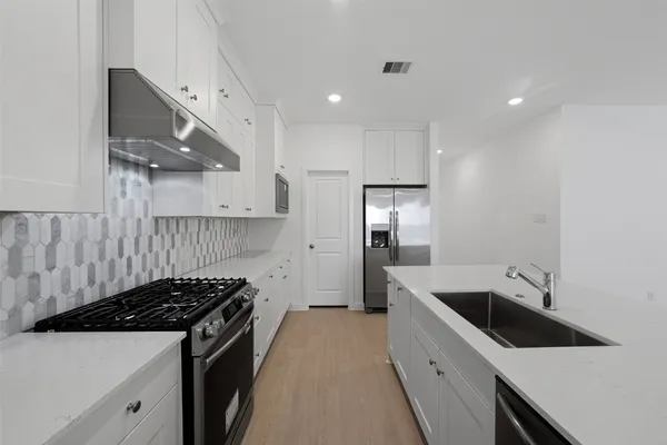 a kitchen with a sink stove and refrigerator
