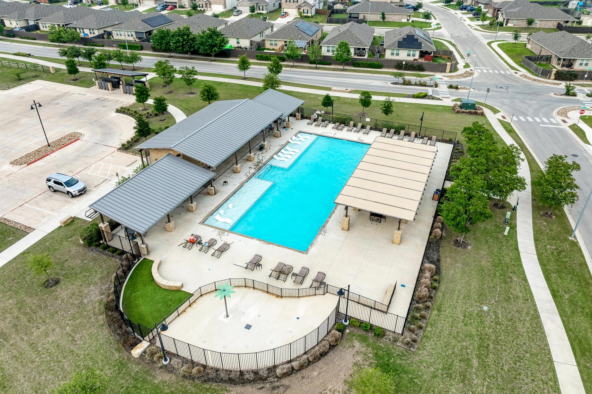 305 Windy Reed Road Hutto, TX 78634 - Photo 32 of 35 A sparkling community pool complex features shaded pavilions and a separate splash pad area.