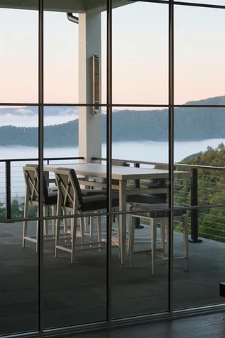 a view of a patio with table and chairs under an umbrella with a small yard