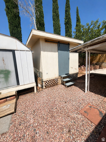 131 Rickie Road Washington, UT 84780 - Photo 7 of 31 Exterior shed with a sliding barn door, lattice skirting, and a small set of steps