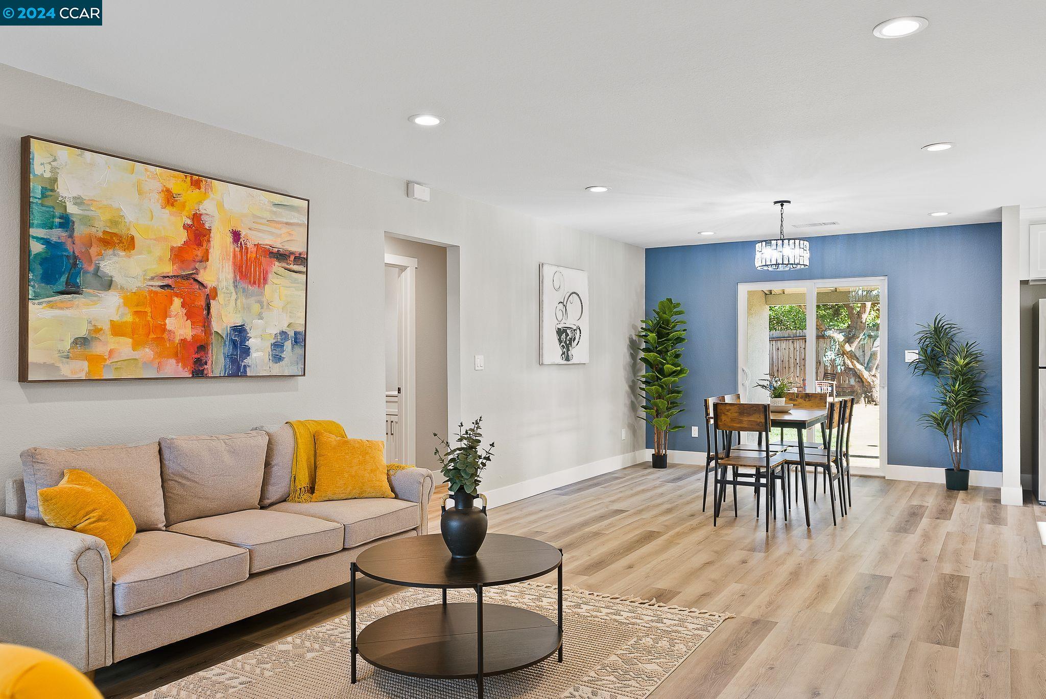 a living room with furniture a dining table and a painting on the wall