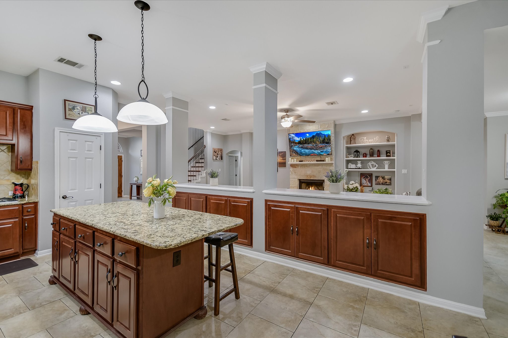 300 Wesley Ridge Drive Spicewood, TX 78669 - Photo 14 of 40 a kitchen with kitchen island granite countertop a stove a sink a refrigerator and a wooden cabinets