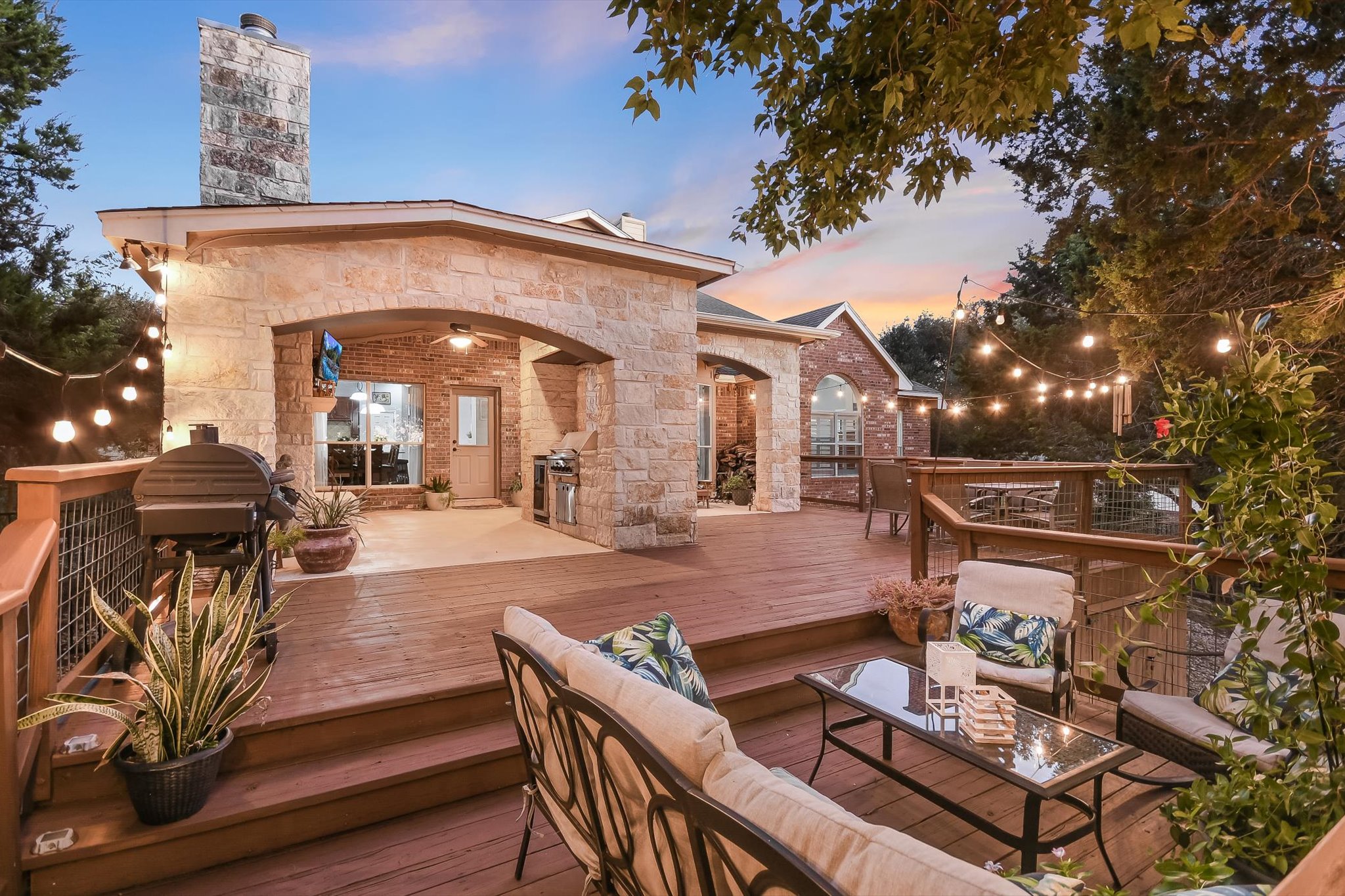 300 Wesley Ridge Drive Spicewood, TX 78669 - Photo 2 of 40 a view of a patio with table and chairs with wooden floor and fence