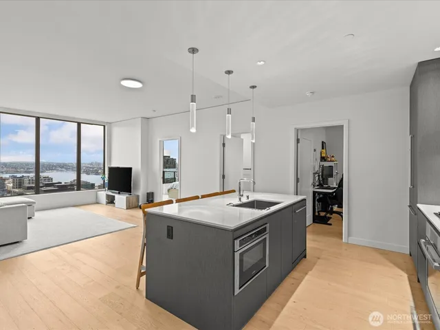 a large kitchen with kitchen island a sink counter space a large window and stainless steel appliances