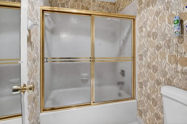 a bathroom with a shower a mirror and a sink