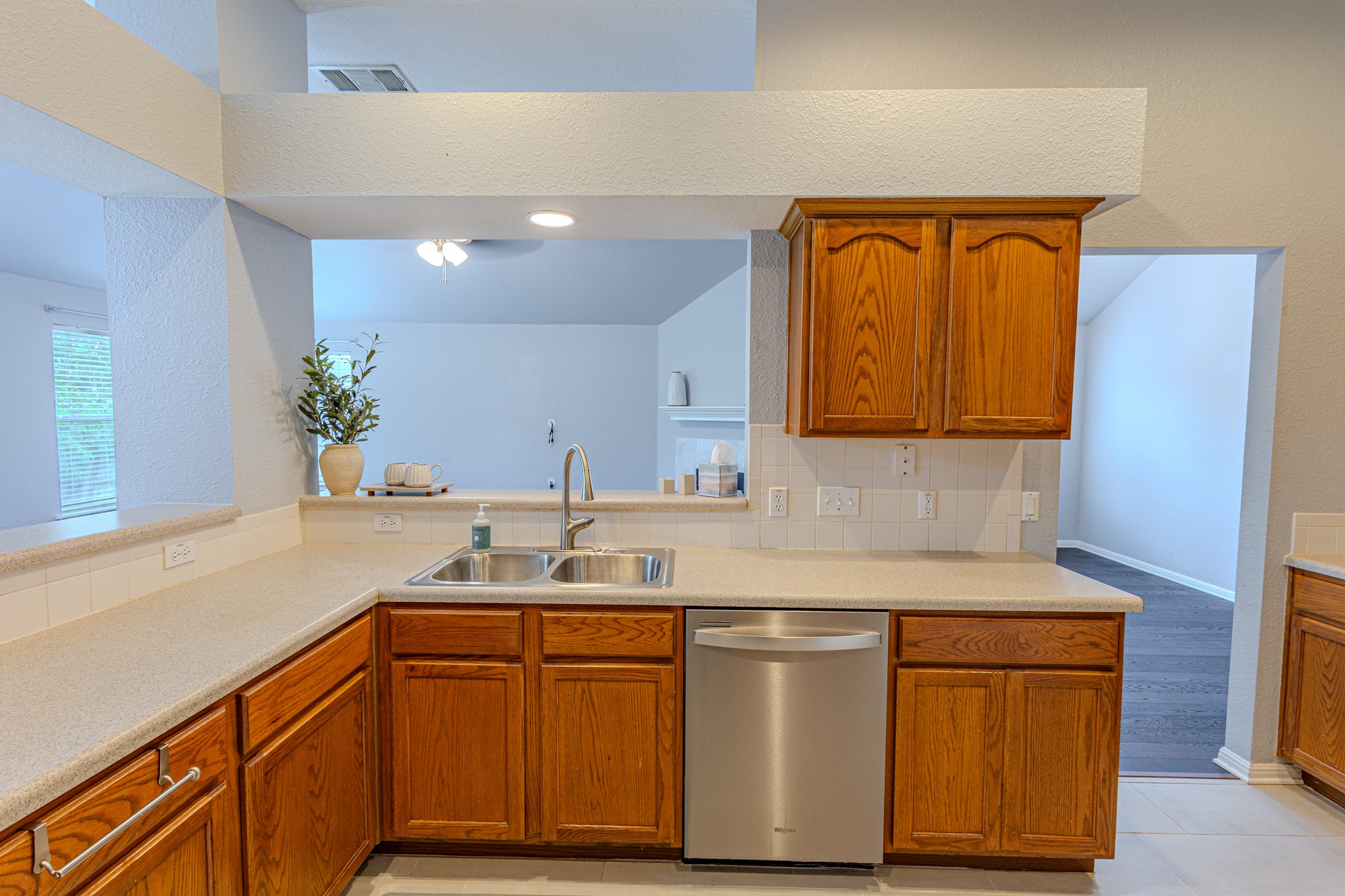 208 Discovery Kyle, TX 78640 - Photo 12 of 31 Kitchen featuring wood cabinetry, light-toned countertops, and a tile backsplash