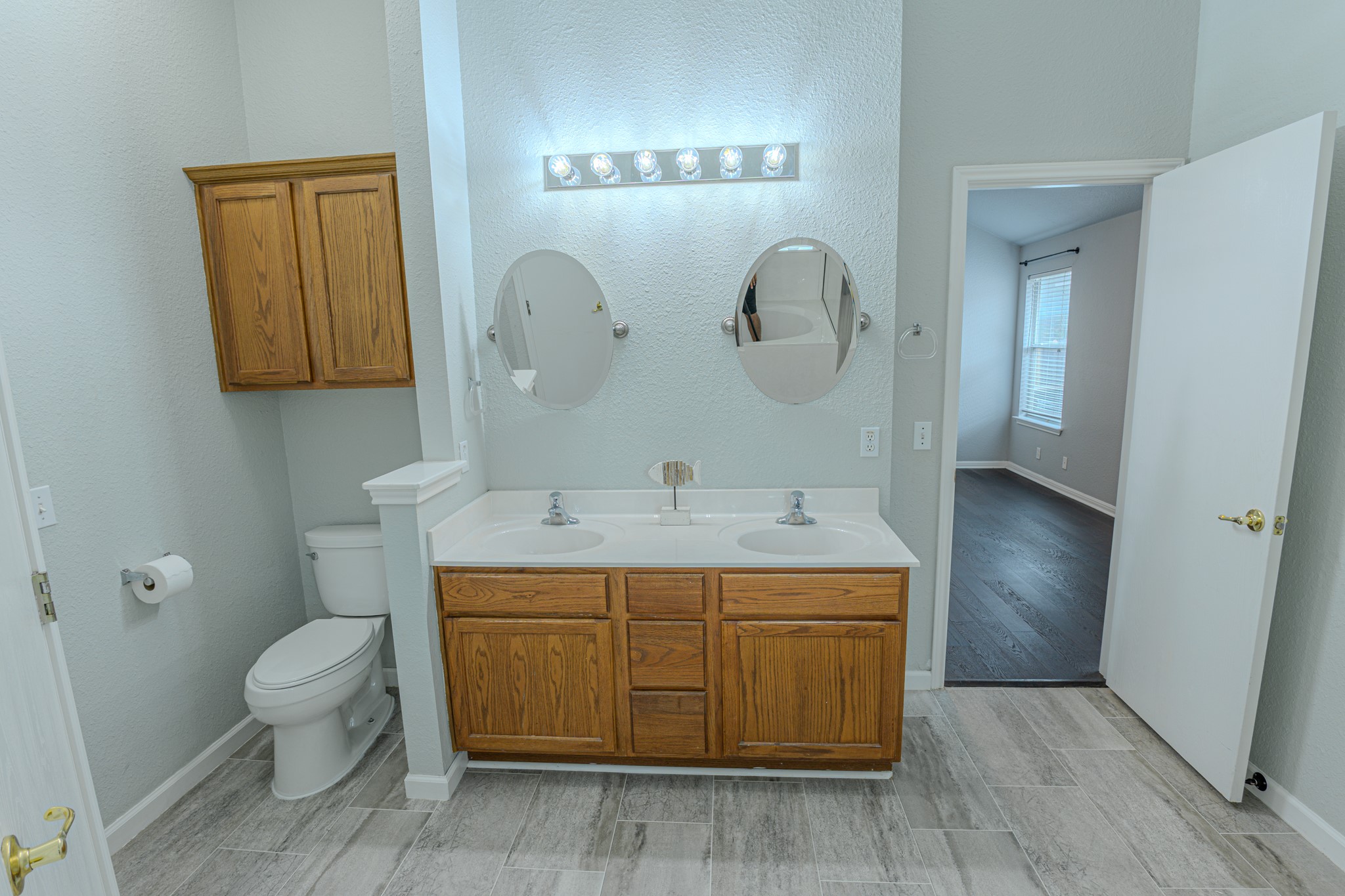 208 Discovery Kyle, TX 78640 - Photo 20 of 31 Bathroom featuring a dual vanity with light wood-finish cabinetry, white countertops, and two circular mirrors