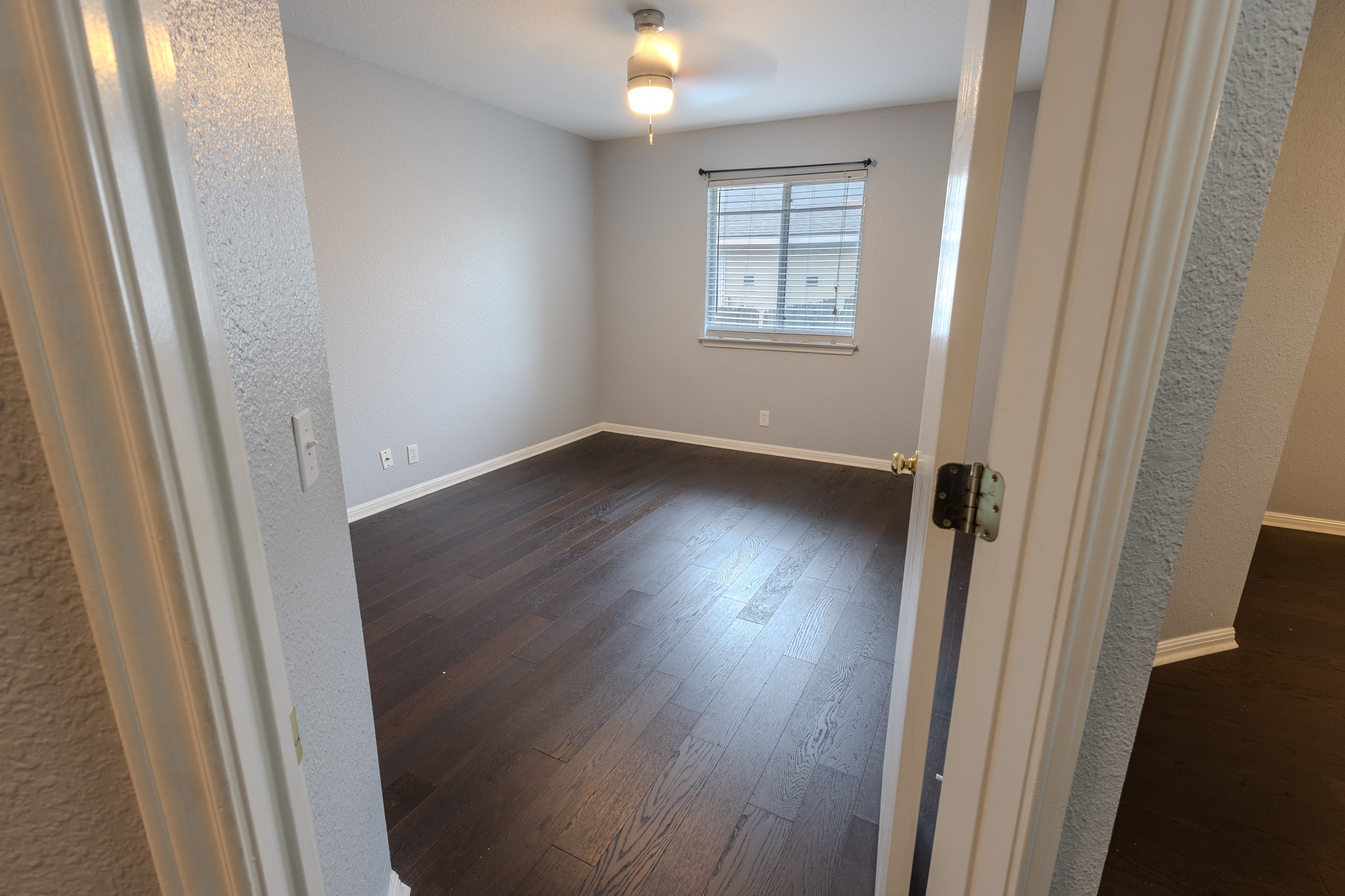 208 Discovery Kyle, TX 78640 - Photo 25 of 31 Spacious room featuring dark wood-finish flooring, light gray walls, and white baseboards