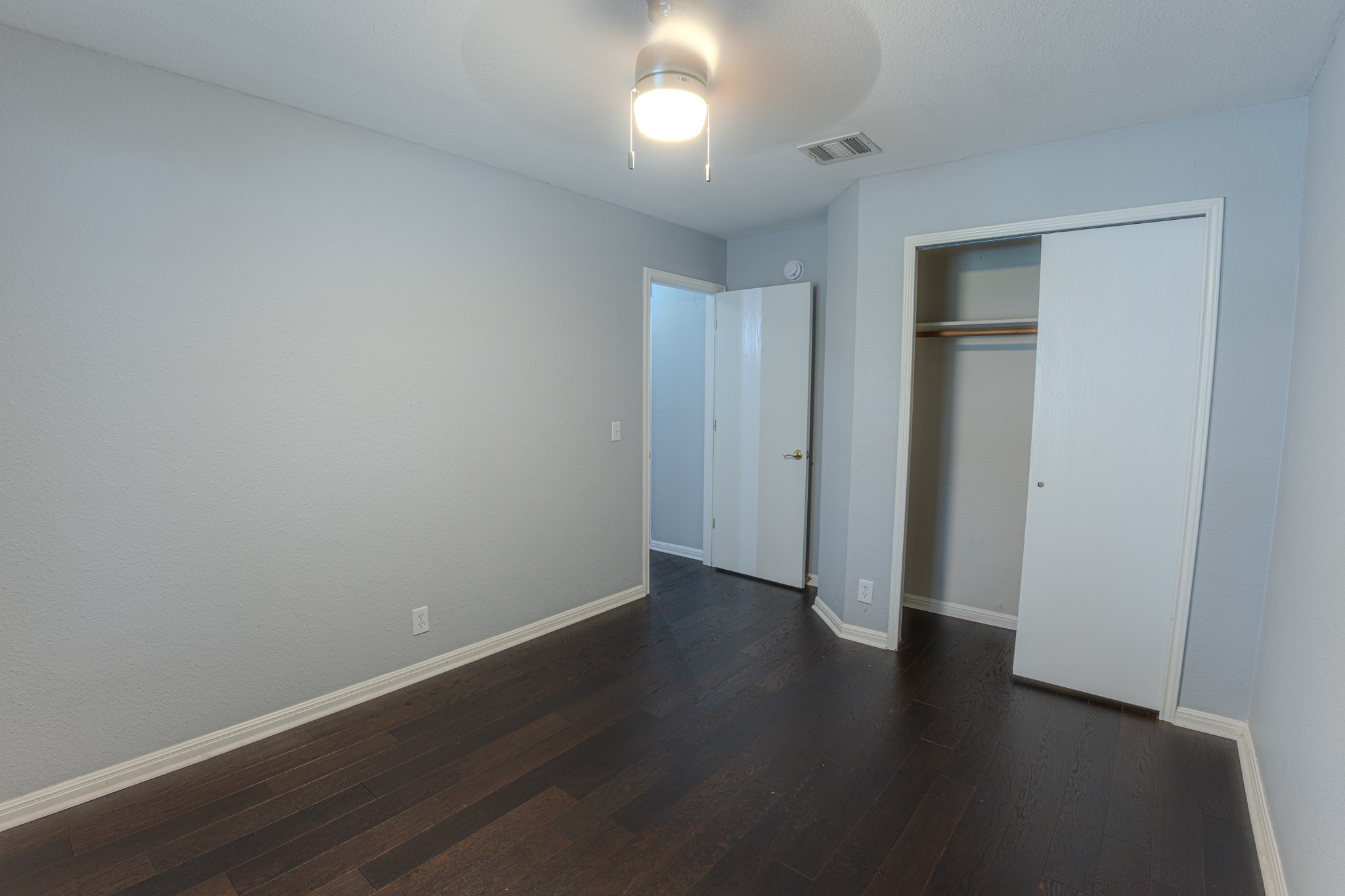 208 Discovery Kyle, TX 78640 - Photo 26 of 31 Room featuring dark wood-finish flooring, light grey painted walls, and white baseboards