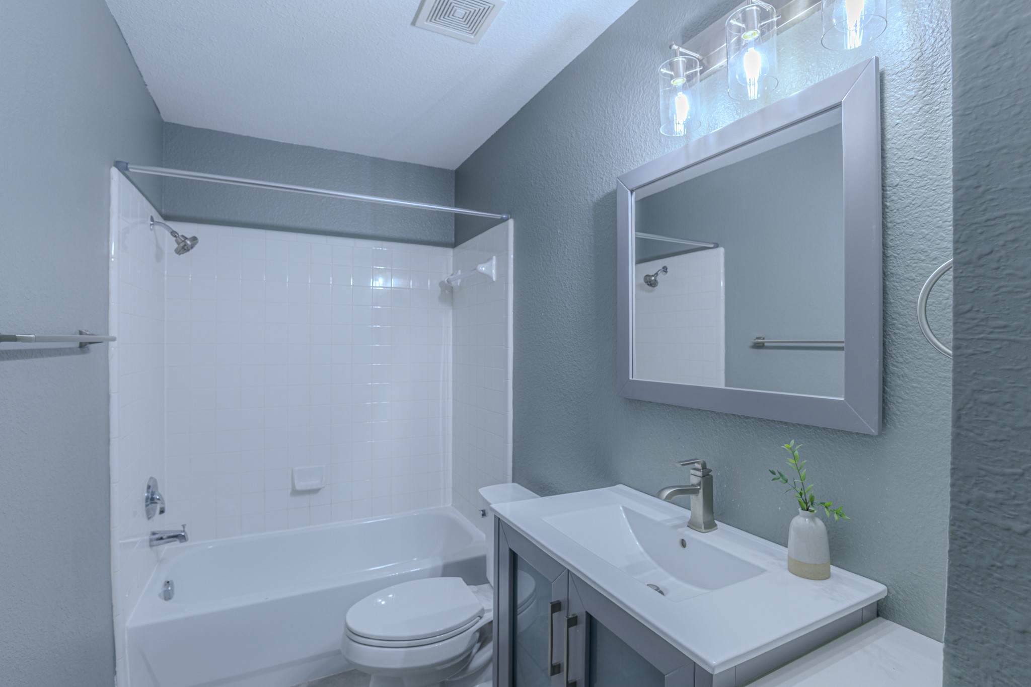 208 Discovery Kyle, TX 78640 - Photo 27 of 31 Bathroom featuring a modern vanity with integrated sink, brushed nickel faucet, framed mirror, and a three-light fixture