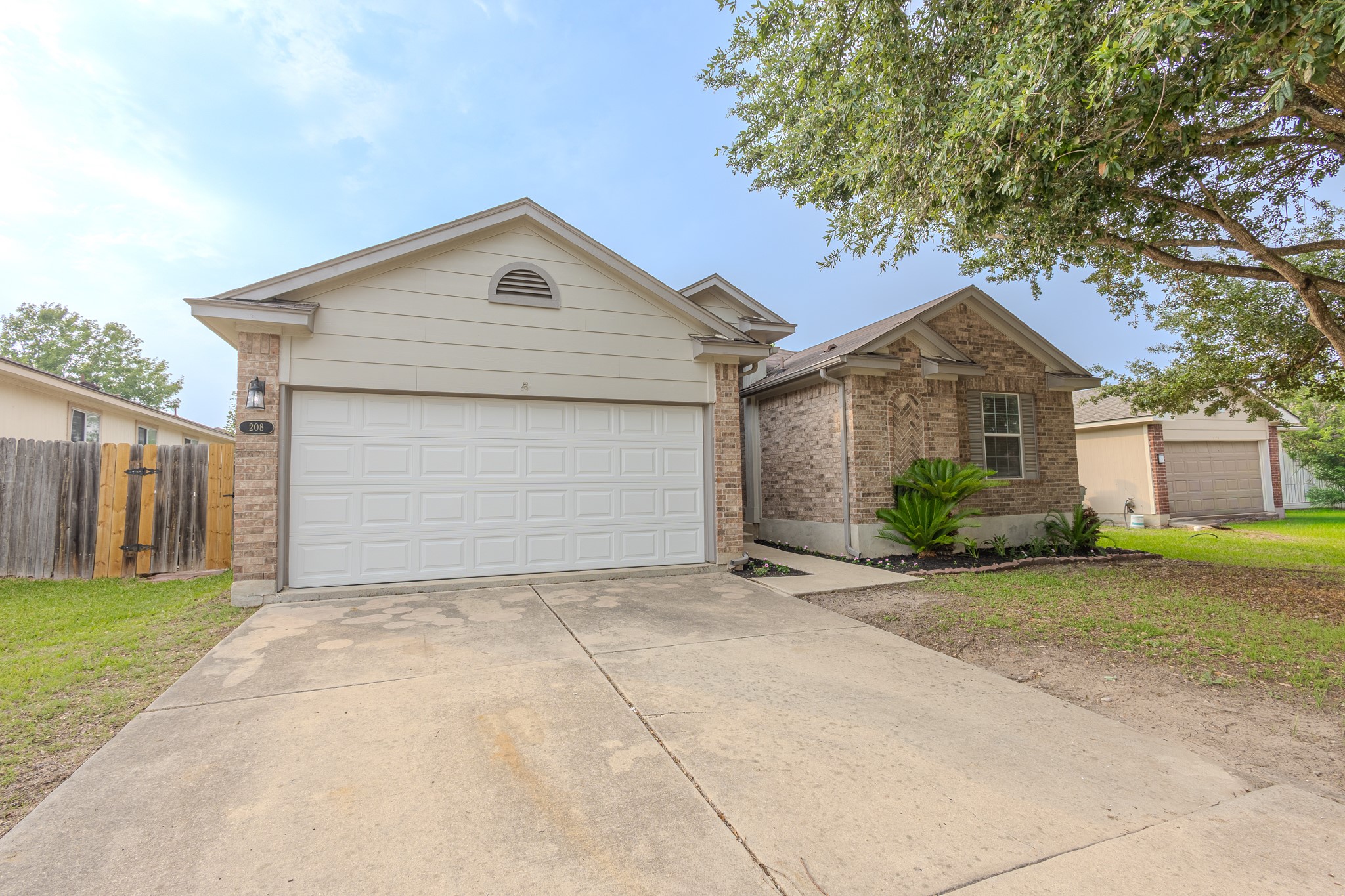 208 Discovery Kyle, TX 78640 - Photo 4 of 31 Single-story residence featuring a two-car garage, brick and siding exterior, and a concrete driveway
