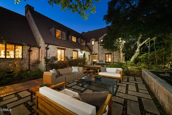a view of a patio with couches table and chairs and potted plants