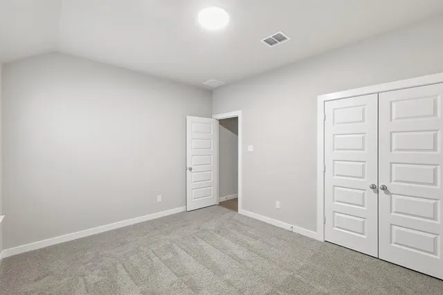 an empty room with closet and fan